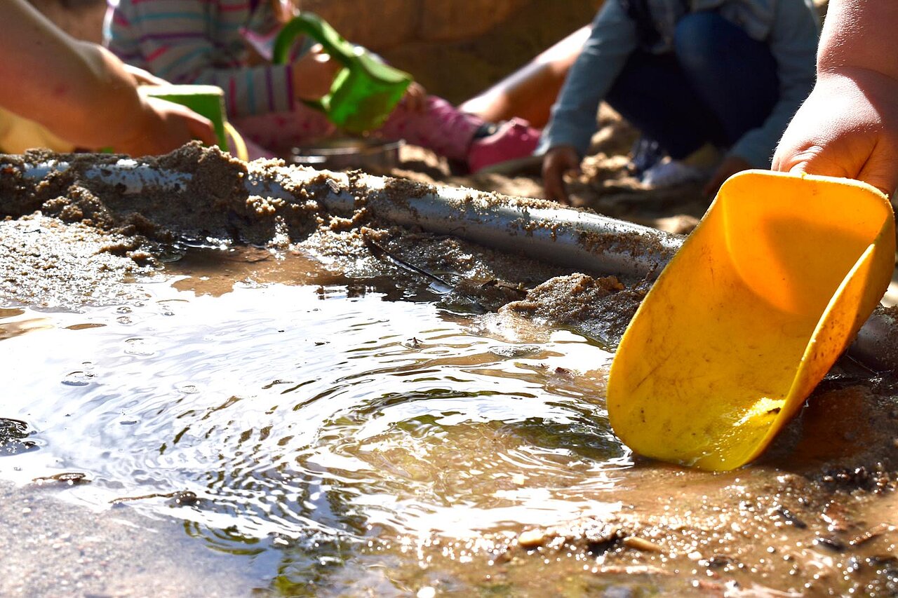 Kinder spielen im Sand